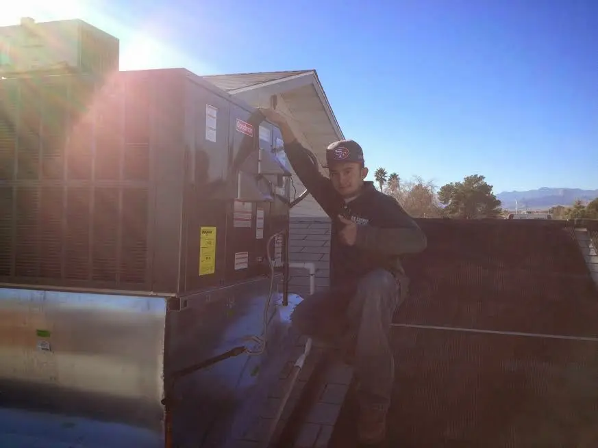 HVAC technician performing Heat Pump Repair on a rooftop unit in Cumming